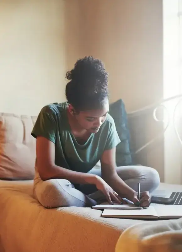 A student studying on a bed